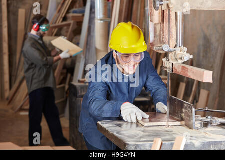 Holzverarbeitung mit Band sah bei Tischlerei Stockfoto