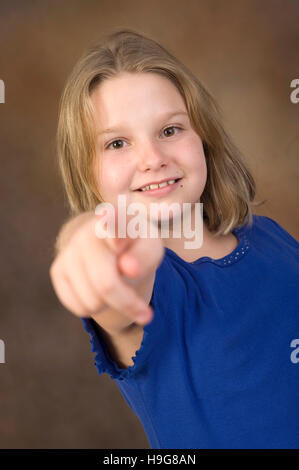 Blonde Mädchen, 8 Jahre alt, zeigt mit dem Zeigefinger Stockfoto