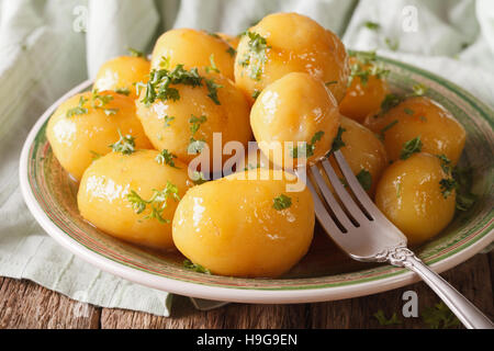 Hausgemachte karamellisierte neue Kartoffeln close-up auf einem Teller. horizontale Stockfoto
