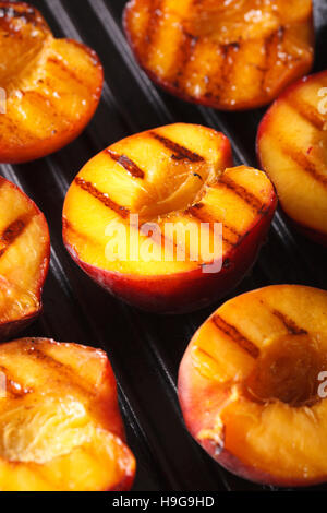 Frische Pfirsiche auf Grill-Makro. vertikale Hintergrund Stockfoto