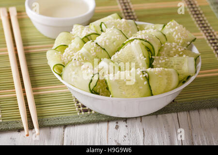 Asiatisch anmutende Salat mit frischen Gurken, Ingwer und Sesam Samen hautnah in eine Schüssel geben. horizontale Stockfoto