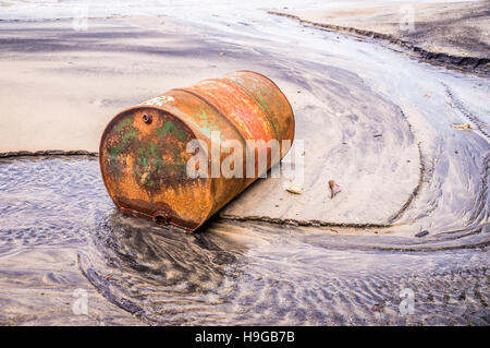 Alte rostige Barrel Öl am Strand Stockfoto