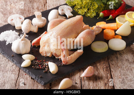 Hausgemachte rohem Hühnerfleisch mit Gemüse und Gewürzen auf einer Schiefertafel Tafel. horizontale Stockfoto