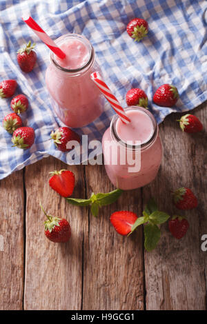 Erfrischende Smoothies Erdbeeren in Großaufnahme Glas Flasche auf dem Tisch. Vertikale Ansicht von oben Stockfoto