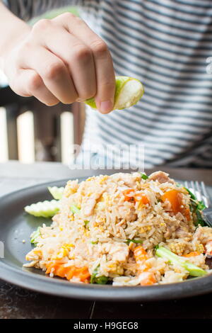 Weibliche Hand drückte Kalk auf gebratener Reis essen Stockfoto