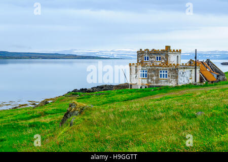 HOLMAVIK, Island - 19. Juni 2016: Blick auf Küste, Landschaft und ein altes Haus mit Graffiti, entlang dem Isafjördur Fjord in der Region West-Fjorde, Stockfoto