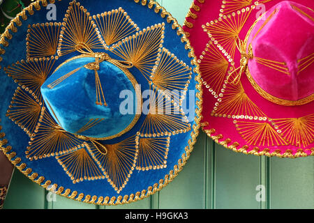 Bunten blauen & rosa mexikanische Hüte oder Sombreros hängt an einer grünen Tür, Cozumel, Halbinsel Yucatan, Quintana Roo, Mexiko. Stockfoto