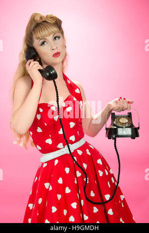 Pin-up Girl mit Vintage Telefon - Nahaufnahme auf rosa Hintergrund Stockfoto