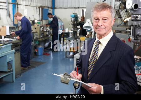 Besitzer des Engineering-Fabrik mit Personal im Hintergrund Stockfoto