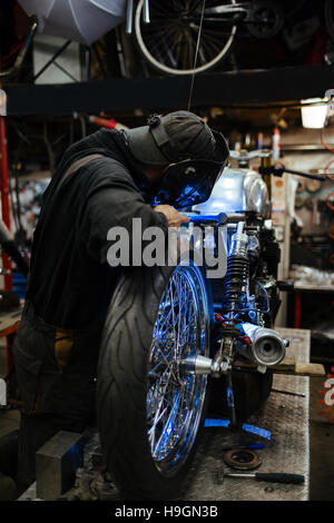 Professionelle Custom-Bike-Mechaniker Schweißen von metallischen Details des Fahrrads in Werkstatt Stockfoto