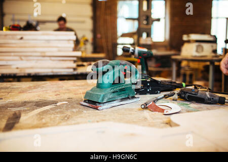 Elektrische Zimmereiwerkzeuge auf hölzernen Tisch oder Werkbank Stockfoto