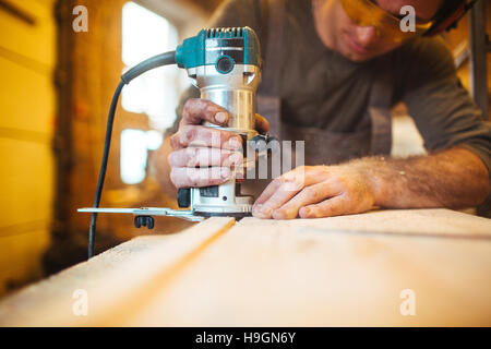 Qualifizierte Handwerker aus Holz Schneidebrett mit elektrischen Holz-router Stockfoto