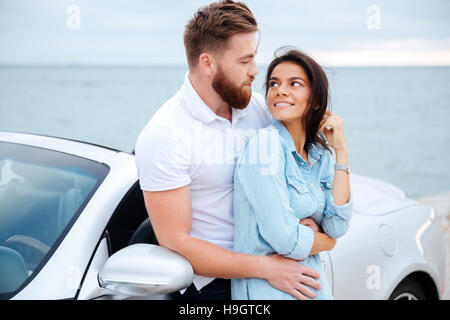 Junge schöne Paar in Liebe an Auto am Meer Stockfoto