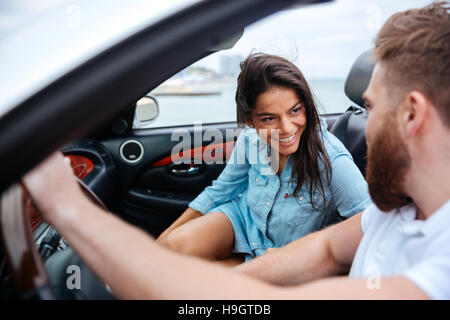 Glücklicher Mann und Frau im Cabrio Auto im freien fahren Stockfoto