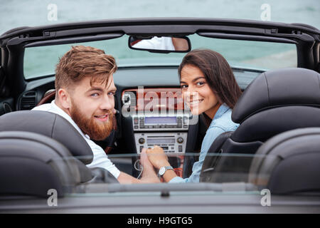Paar im Rückblick und lächelnd in weißen Cabriolet im freien Stockfoto