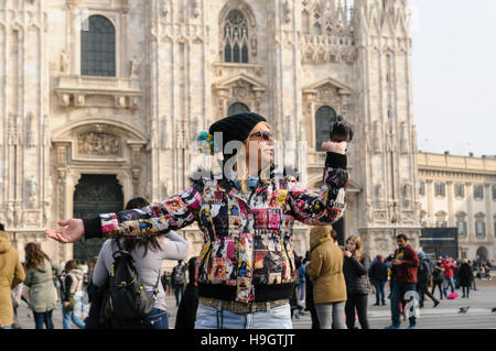 Eine Frau hält Lebensmittel für Tauben auf der Piazza del Duomo, Mailand, Italien Stockfoto