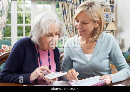 Weibliche Nachbarn helfen, ältere Frau mit heimischen Finanzen Stockfoto
