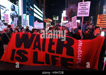 New York, USA. 23. November 2016. Aktivisten halten ein Banner, Wasser ist Leben, in Times Square, New York City. Demonstranten versammelt in Reaktion auf die jüngsten Ereignisse am Standing Rock, North Dakota; und das Gebäude der Dakota Zugang Pipeline zu widersetzen. Stockfoto