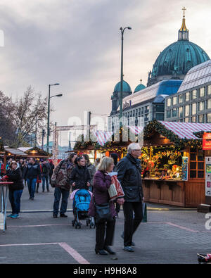 Berlin, Deutschland, 23. November 2016. Die Berliner Weihnachtzeit ist ein deutscher Weihnachtsmarkt rund um den historischen Neptunbrunnen (Neptunbrunnen) hinter Alexanderplatz gelegen. Die festliche hölzerne Marktstände befinden sich zwischen das Rotes Rathaus (Rotes Rathaus) und der Marienkirche. Eine festliche Atmosphäre erfolgt durch Drehorgel Musik, Glühwein, Stände verkaufen Kunsthandwerk, Brot in einer traditionellen Bäckerei und heißen Met gebacken aus Tonkrügen serviert. Besucher genießen eine Eisbahn und das 50 Meter hohe Riesenrad mit traditionellen Gondeln. Kinder genießen Sie Besuche zu den Streichelzoo, Pony zu befreien Stockfoto