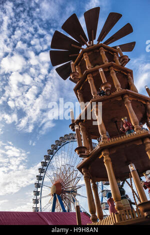 Berlin, Deutschland, 23. November 2016. Die Berliner Weihnachtzeit ist ein deutscher Weihnachtsmarkt rund um den historischen Neptunbrunnen (Neptunbrunnen) hinter Alexanderplatz gelegen. Die festliche hölzerne Marktstände befinden sich zwischen das Rotes Rathaus (Rotes Rathaus) und der Marienkirche. Eine festliche Atmosphäre erfolgt durch Drehorgel Musik, Glühwein, Stände verkaufen Kunsthandwerk, Brot in einer traditionellen Bäckerei und heißen Met gebacken aus Tonkrügen serviert. Besucher genießen eine Eisbahn und das 50 Meter hohe Riesenrad mit traditionellen Gondeln. Kinder genießen Sie Besuche zu den Streichelzoo, Pony zu befreien Stockfoto