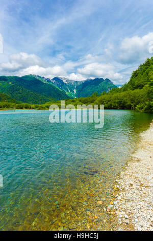 Landschaft des türkisfarbenen Wasser des Taisho Teich Küstenlinie mit Natur Blick auf Mount Hotaka-Dake im Hintergrund Sommertag Kamikochi Stockfoto