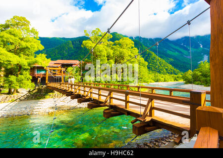 Blick auf Mount Hotaka hinter Kappa Bashi Brücke über dem klaren, türkisfarbenen Wasser des Azusa-Flusses in den japanischen Alpen, Kamikochi, Japan Stockfoto