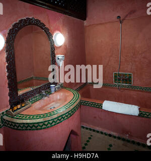 Badezimmer im Riad Arabesque in Fès, Marokko. Im Sanitärbereich sind die Becken nicht aus Porzellan, sondern, wie die Wände, aus dem traditionellen marokkanischen Tadelekt-Material und emaillierten Terrakotta-Fliesen Stockfoto