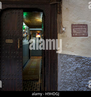 Eingang des Riad Arabesque, Fès, Marokko. Ein dunkler Eingang an einer verbietenden Wand lässt sogar Zweifel aufkommen, ob sich die Tür öffnet, wenn man die Glocke läutet Stockfoto