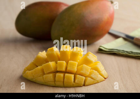 Frische reife saftige halbe gelbe Mango und ganz im Hintergrund Stockfoto