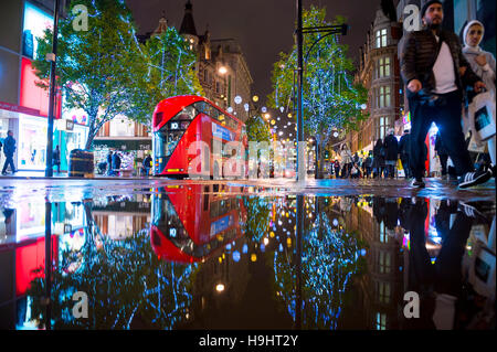 LONDON - 16. November 2016: Roten Doppeldecker-Bus mit Urlaub Lichter reflektiert, wie Fußgänger drängen sich Oxford Street. Stockfoto