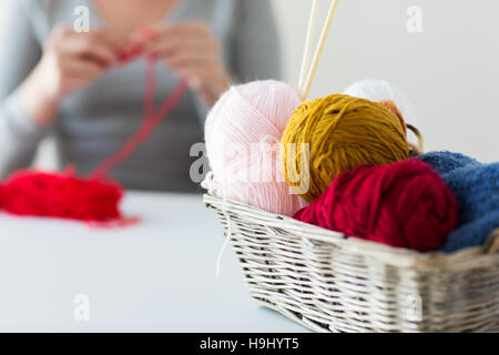 Frau, Korb mit Stricknadeln und Garn Kugeln Stockfoto