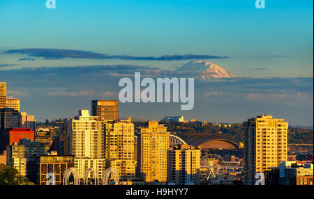 Mount Rainier erhebt sich über einen Teil von Seattle in der Abend-Sonne Stockfoto