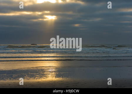 Sonnenstrahl stossen durch dicke Wolkendecke über einen pazifischen Strand im Nordwesten Washingtons Stockfoto