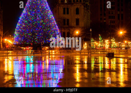 Der große beleuchtete Weihnachtsbaum in Syracuse NY spiegelt sich im nassen Eisbahn auf Clinton Square Stockfoto