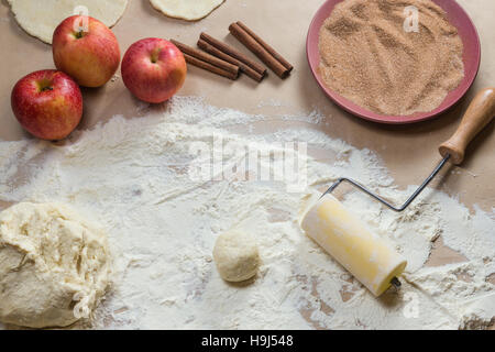 Zutaten für die Zubereitung Kekse mit Zimt, Quark und Äpfel auf Kraftpapier. Ansicht von oben. Flache Komposition. Hausgemachte Mehlspeisen. Weihnachts-Tradition backen, Kuchen Kekse. Sehr lecker. Stockfoto