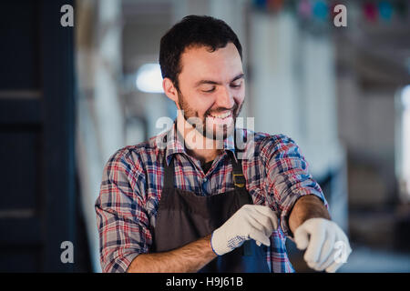 Glückliche junge Handwerker Tischler in Werkstatt, Lächeln Stockfoto