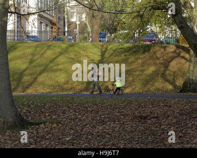 Glasgow Park Szene Vater und Kind unter der Leitung von führen auf Fahrrad Stockfoto