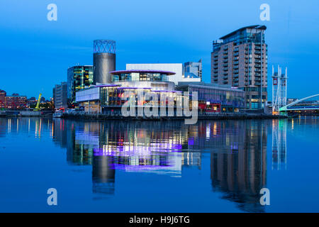 Das Lowry Arts Centre in der Abenddämmerung, spiegelt sich in den Manchester Ship Canal, Salford Quays, Manchester, England, UK Stockfoto