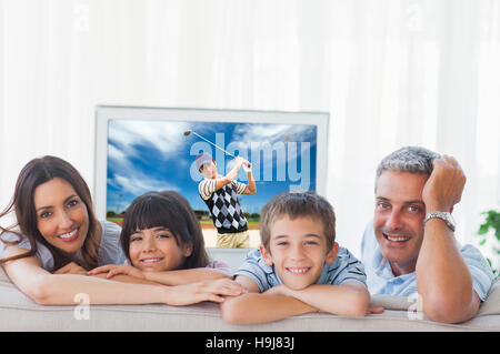 Zusammengesetztes Bild der Familie im Wohnzimmer in die Kamera Lächeln Stockfoto