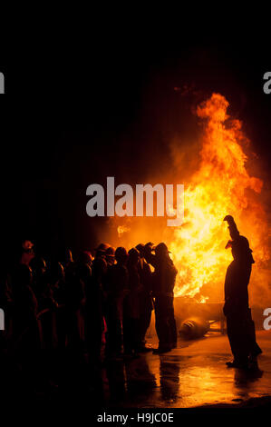 Silhouette der Feuerwehrleute kämpfen ein wütendes Feuer mit riesigen Flammen des brennenden Holzes Stockfoto