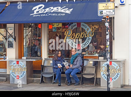 Stadt von London A paar genießen Sie ihre Mahlzeit im Poppies traditionellen Fish And Chips Restaurant in der Hanbury Street, Spitalfields Stockfoto