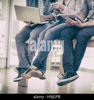 Drei kreative Business-Team arbeiten an elektronischen Geräten Stockfoto