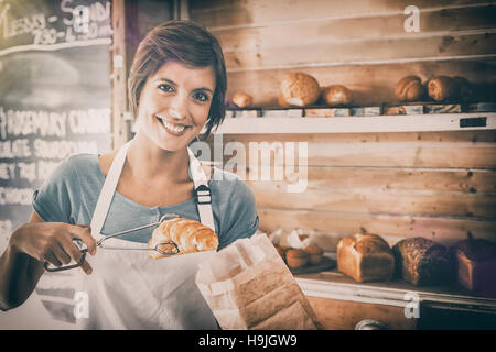 Hübsche Kellnerin hob croissant Stockfoto