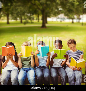 Zusammengesetztes Bild von Kindern Lesen von Büchern im park Stockfoto