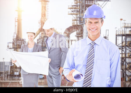 Zusammengesetztes Bild von Geschäftsleuten und eine Frau mit harten Hüte und Holding Blaupause Stockfoto