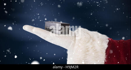 Zusammengesetztes Bild Santas Hand zeigt eine kleine box Stockfoto