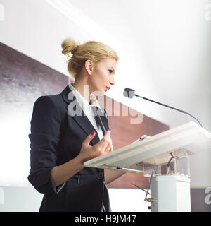 Hübsche, junge Geschäftsfrau hält einen Vortrag in einer Konferenz/Meeting-Einstellung (flachen DOF; getönten Farbbild) Stockfoto