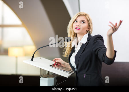 Hübsche, junge Geschäftsfrau hält einen Vortrag in einer Konferenz/Meeting-Einstellung (flachen DOF; getönten Farbbild) Stockfoto