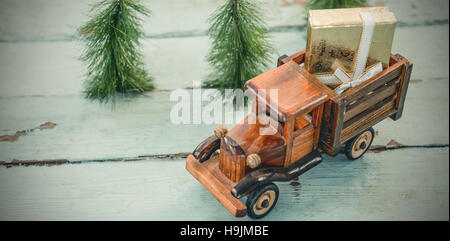 Spielzeug-Tempo mit Weihnachtsgeschenk auf Holzbrett Stockfoto