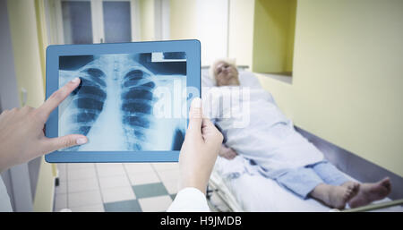 Zusammengesetztes Bild des Arztes betrachten Xray auf tablet Stockfoto